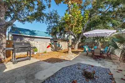 a backyard with a grill and a table and chairs at Fanta Sea - Private Seasonal Hot Tub, Game Room, Walk to Beach, Pets OK, & More! in Panama City Beach