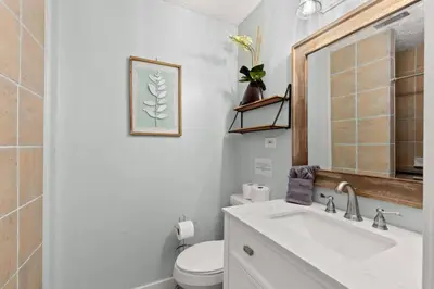 a bathroom with a sink and a toilet and a mirror at Fanta Sea - Private Seasonal Hot Tub, Game Room, Walk to Beach, Pets OK, & More! in Panama City Beach