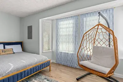 a bedroom with a bed and a swing in a room at Fanta Sea - Private Seasonal Hot Tub, Game Room, Walk to Beach, Pets OK, & More! in Panama City Beach