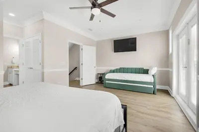 a white bedroom with a bed and a couch at Bella Costa 160- Sandy Feet Retreat in Panama City Beach