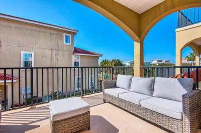 a patio with a couch on a balcony at Bella Costa 160- Sandy Feet Retreat in Panama City Beach