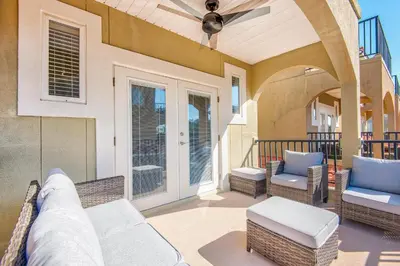 a porch with wicker chairs and a ceiling fan at Bella Costa 160- Sandy Feet Retreat in Panama City Beach
