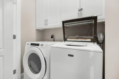 a kitchen with a washing machine and a microwave at Bella Costa 160- Sandy Feet Retreat in Panama City Beach