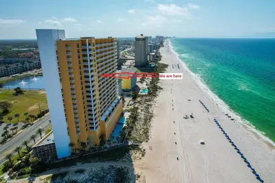 an aerial view of a beach with a building and the ocean at Emerald Chic BeachFront 2 bdr apt 4 beach seats and a cannope on us in Panama City Beach