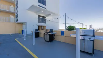 a balcony of an apartment building with a desk and appliances at Emerald Chic BeachFront 2 bdr apt 4 beach seats and a cannope on us in Panama City Beach