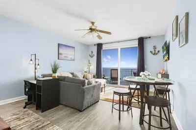 a living room with a couch and a table at Emerald Chic BeachFront 2 bdr apt 4 beach seats and a cannope on us in Panama City Beach