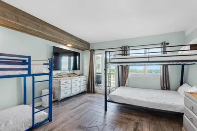 a bedroom with two bunk beds and a bathroom at Pinnacle Port A-910 in Panama City Beach
