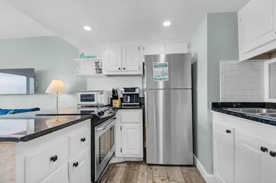 a kitchen with white cabinets and a stainless steel refrigerator at Pinnacle Port A-910 in Panama City Beach