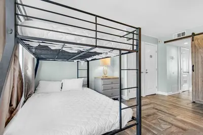 a bedroom with two bunk beds and a desk at Pinnacle Port A-910 in Panama City Beach