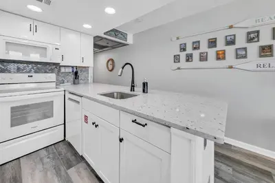 a white kitchen with a sink and a stove at Sunbird 404E in Panama City Beach