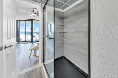 a glass shower in a bathroom with a view of the ocean at Sunbird 404E in Panama City Beach