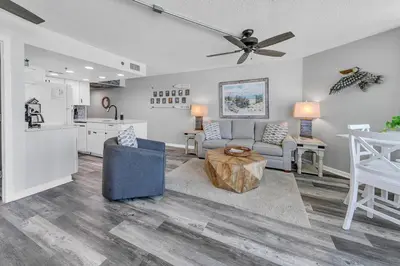 a living room with a couch and a kitchen at Sunbird 404E in Panama City Beach