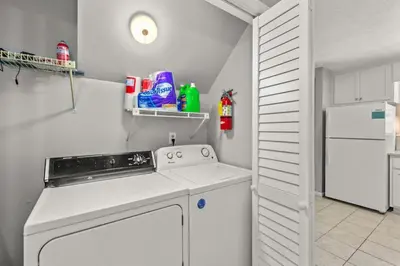 a white kitchen with a stove and a white refrigerator at Beach Haven - Seasonal Hot Tub, Fire Pit, BBQ, 700 Feet to Beach, Central PCB, FREE Daily Activities, & More! in Panama City Beach