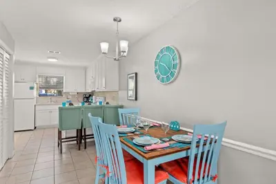 a kitchen and dining room with a table and chairs at Beach Haven - Seasonal Hot Tub, Fire Pit, BBQ, 700 Feet to Beach, Central PCB, FREE Daily Activities, & More! in Panama City Beach