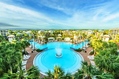 an aerial view of a resort swimming pool with palm trees at The Eagles Nest in Rosemary Beach
