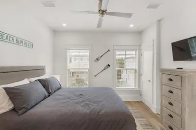 a bedroom with a bed and a flat screen tv at The Eagles Nest in Rosemary Beach
