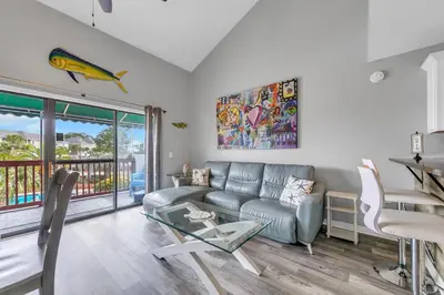 a living room with a couch and a glass table at St Thomas Square Villa 414 in Panama City Beach
