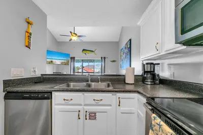 a kitchen with white cabinets and a sink at St Thomas Square Villa 414 in Panama City Beach
