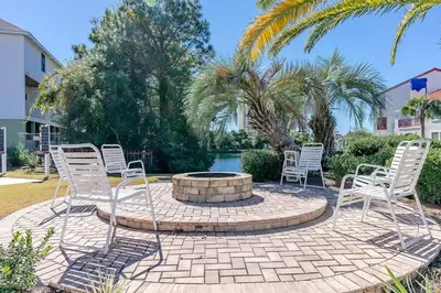 a group of chairs sitting around a fire pit at St Thomas Square Villa 414 in Panama City Beach