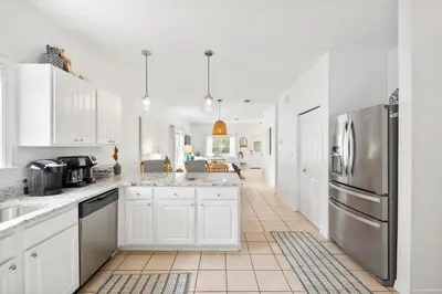 a kitchen with white cabinets and stainless steel appliances at 30A Beach House - Coconut Cottage by Panhandle Getaways in Santa Rosa Beach
