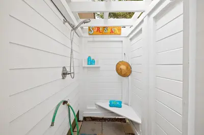 a small bathroom with a white wall and a sink at 30A Beach House - Coconut Cottage by Panhandle Getaways in Santa Rosa Beach