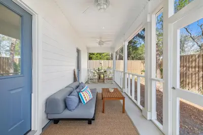 a porch with a couch and a table at 30A Beach House - Coconut Cottage by Panhandle Getaways in Santa Rosa Beach