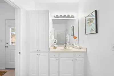 a white bathroom with a sink and a mirror at 30A Beach House - Coconut Cottage by Panhandle Getaways in Santa Rosa Beach