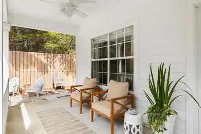 a white porch with chairs and a window at 30A Beach House - Coconut Cottage by Panhandle Getaways in Santa Rosa Beach