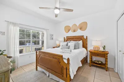 a bedroom with a wooden bed and a window at 30A Beach House - Coconut Cottage by Panhandle Getaways in Santa Rosa Beach