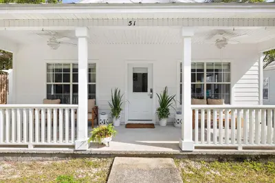 a white house with a porch with plants on it at 30A Beach House - Coconut Cottage by Panhandle Getaways in Santa Rosa Beach