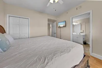 a bedroom with a large white bed and a sink at Majestic Beach Towers 1-407 in Panama City Beach