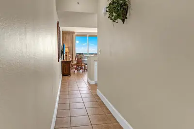 a hallway with a view of a kitchen and a dining room at Majestic Beach Towers 1-407 in Panama City Beach