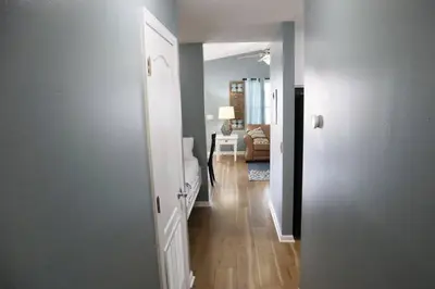 a hallway leading to a living room with a couch at Lazy Palm 4 Pools Short Walk To Beach! Sleeps 5! in Panama City Beach