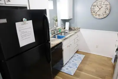 a kitchen with a black refrigerator with a sign on it at Lazy Palm 4 Pools Short Walk To Beach! Sleeps 5! in Panama City Beach