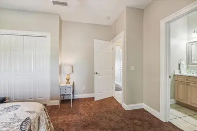 a bedroom with a bed and a bathroom with a sink at Second Wind by Book That Condo in Panama City Beach