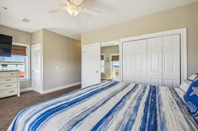 a bedroom with a bed and a ceiling fan at Second Wind by Book That Condo in Panama City Beach