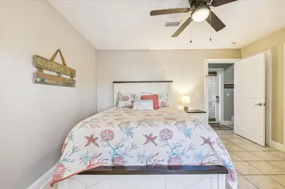 a bedroom with a bed and a ceiling fan at Second Wind by Book That Condo in Panama City Beach
