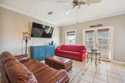 a living room with a couch and a red chair at Second Wind by Book That Condo in Panama City Beach