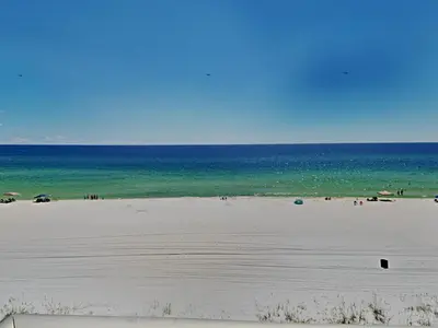 a beach with people and the ocean in the background at Edgewater Leeward #500 in Panama City Beach
