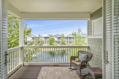 a porch with a chair and a view of the water at Beach Bliss 30A in Destin