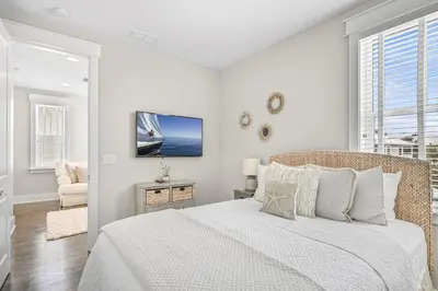 a white bedroom with a bed and a tv at Beach Bliss 30A in Destin