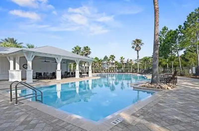 a swimming pool at a resort with a palm tree at Beach Bliss 30A in Destin