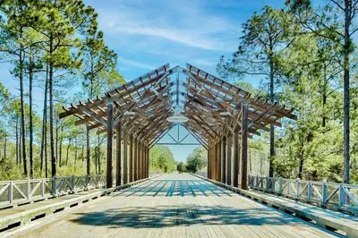 a wooden bridge in a park with trees at Beach Bliss 30A in Destin
