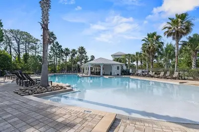 a large swimming pool with a gazebo and palm trees at Beach Bliss 30A in Destin