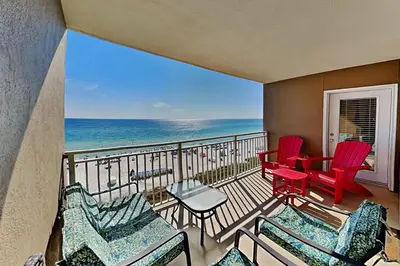 a balcony with chairs and a table and the ocean at Emerald Beach #630 in Panama City Beach