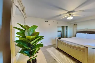 a bedroom with a bed and a plant in it at Emerald Beach #630 in Panama City Beach