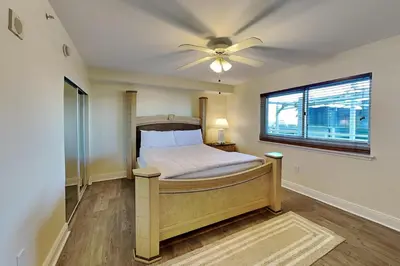 a bedroom with a bed with a ceiling fan at Emerald Beach #630 in Panama City Beach