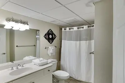 a bathroom with a toilet and a sink and a shower at Emerald Beach #630 in Panama City Beach