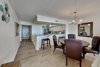 a dining room and kitchen with a table and chairs at Emerald Beach #630 in Panama City Beach