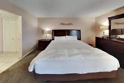 a bedroom with a large white bed and a mirror at Edgewater Tower II 905 in Panama City Beach